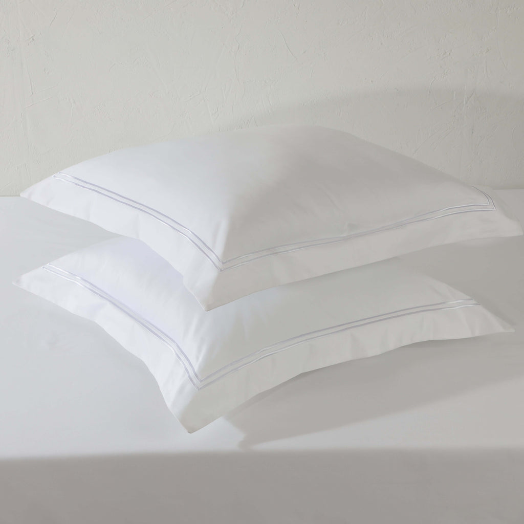 Flat lay of two white euro organic cotton pillowcases – 1000 TC with double-stitched embroidery, 65x65cm