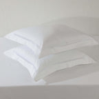 Flat lay of two white euro organic cotton pillowcases – 1000 TC with double-stitched embroidery, 65x65cm