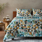 Bed with colourful geometric patterned bedding in a room setting.