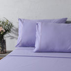 200TC dyed organic cotton percale sheet set in Lavender Mist on a made bed – soft pastel lavender, minimalistic embroidery, gentle on skin, Whites of London