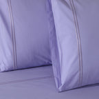 Close-up of Lavender Mist organic cotton percale pillowcase embroidery – understated stitching on a soft pastel lavender 200TC dyed sheet set, Whites of London India