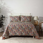 Paisley Romance reversible dohar set on a styled bed – vibrant paisley print in teal, coral, rose and gold on ivory organic cotton percale, Whites of London