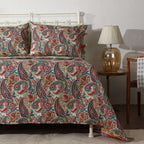 Close-up of intricate paisley motifs on ivory percale – swirling teal, coral and gold accents on the Paisley Romance quilted dohar