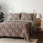 Paisley Romance quilted dohar set on a made bed – side angle view with paisley motifs in rich teal and coral tones