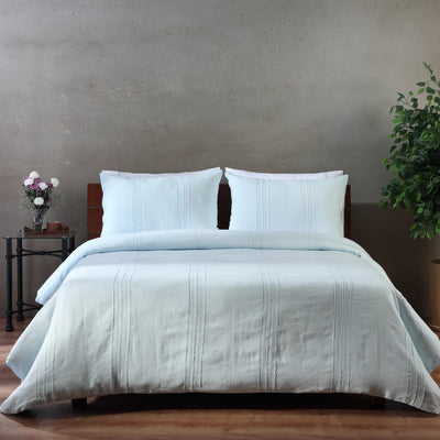 Glacier Blue European flax linen duvet cover set on a luxury styled bed – hand-tailored pintucks and Victorian hemstitching, 100% pure linen, Whites of London India