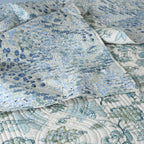 Close-up of wave-stitched quilting on the Jacobean Windflower cotton percale dohar – delicate blush-coral blooms on an ivory cotton ground, reversible design