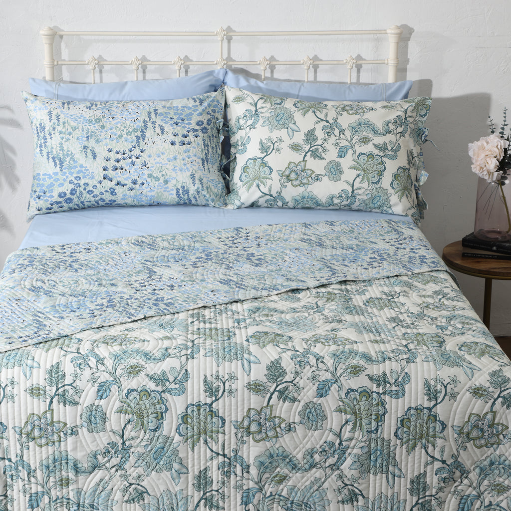 Flat lay of Jacobean Windflower reversible dohar – ivory botanical front alongside coral and terracotta reverse, 100% cotton percale with wave-stitch quilting