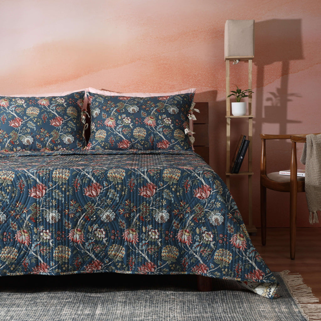 Flat lay of Chintz cotton percale reversible dohar – deep blue botanical front alongside ivory and coral floral reverse, 100% organic cotton