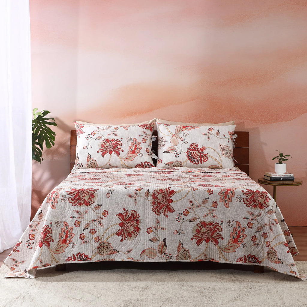 Jacobean Summer reversible dohar set on a styled bed – ivory ground with blush-coral botanical blooms and slate-blue vines, wave-quilted cotton percale, Whites of London