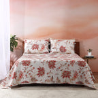 Jacobean Summer reversible dohar set on a styled bed – ivory ground with blush-coral botanical blooms and slate-blue vines, wave-quilted cotton percale, Whites of London