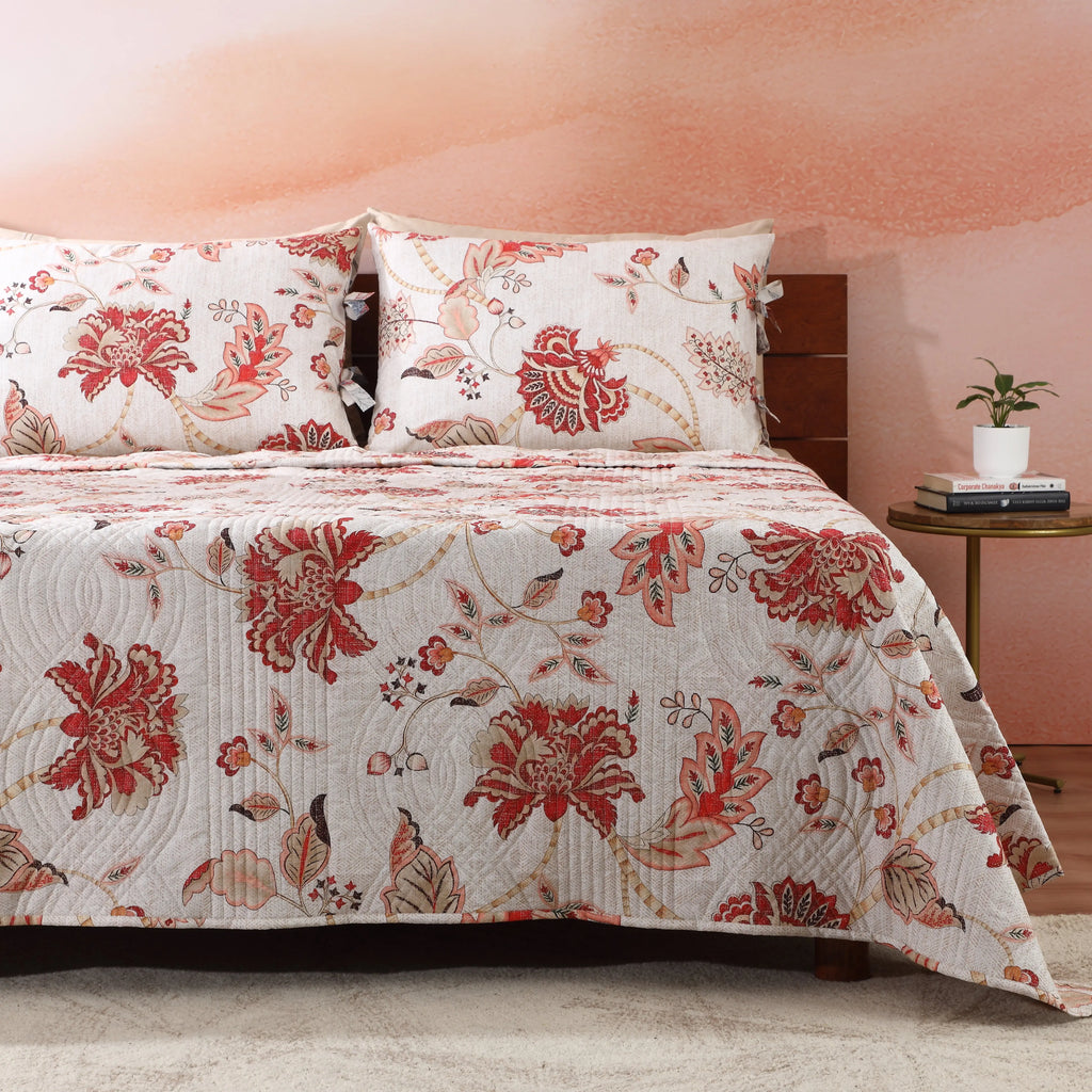 Close-up of wave-stitched quilting and blush-coral botanical print on the Jacobean Summer percale dohar – delicate Jacobean floral motifs on an ivory cotton percale ground