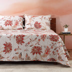 Close-up of wave-stitched quilting and blush-coral botanical print on the Jacobean Summer percale dohar – delicate Jacobean floral motifs on an ivory cotton percale ground