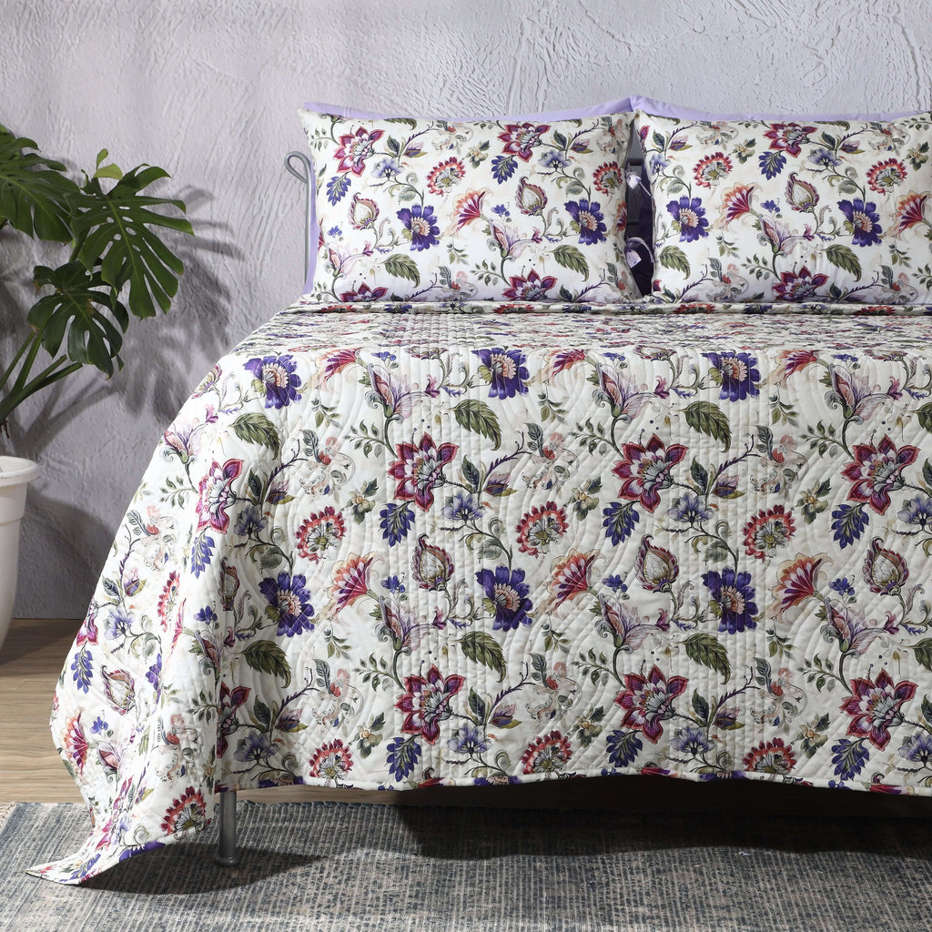 Lavender Fields percale dohar set on a made bed – painterly floral design in lilac, sage and blush tones, lightly quilted organic cotton