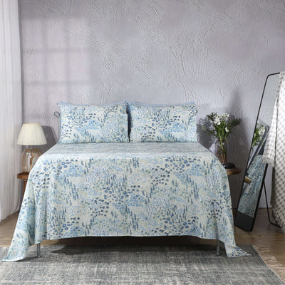 Windflower sheet set on a styled bed – meadow-inspired wildflower print in soft blue, sage and ivory on 200 TC organic cotton percale, Whites of London