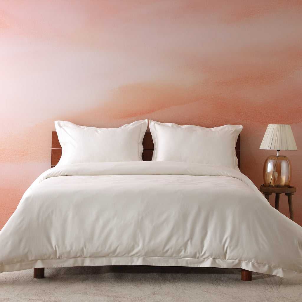 Ivory 600TC organic cotton duvet cover set on a luxury styled bed – warm ivory tone, fluid drape with marrow embroidery detail, soft and breathable, Whites of London India