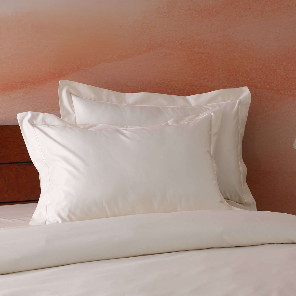Ivory oxford pillowcase set on a styled bed – 600 TC organic cotton with embroidered flange detail, by Whites of London India