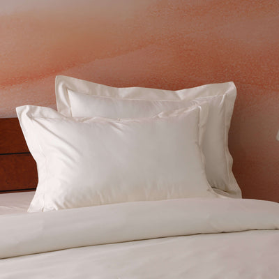 Ivory oxford pillowcase set on a styled bed – 600 TC organic cotton with embroidered flange detail, by Whites of London India