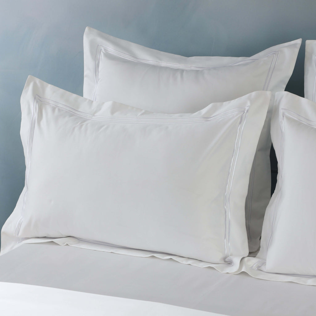 Pair of white 1000 thread count organic cotton pillowcases on a made bed – embroidered double-line detail, Whites of London India