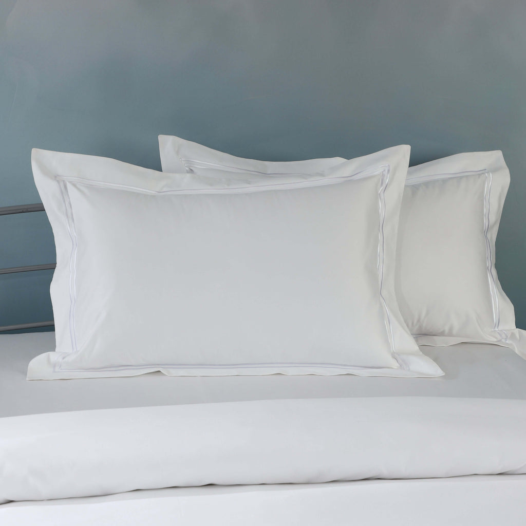 White organic cotton embroidered pillowcase set on a styled bed – 1000 TC organic cotton with double embroidered border detail, Whites of London