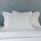White organic cotton embroidered pillowcase set on a styled bed – 1000 TC organic cotton with double embroidered border detail, Whites of London