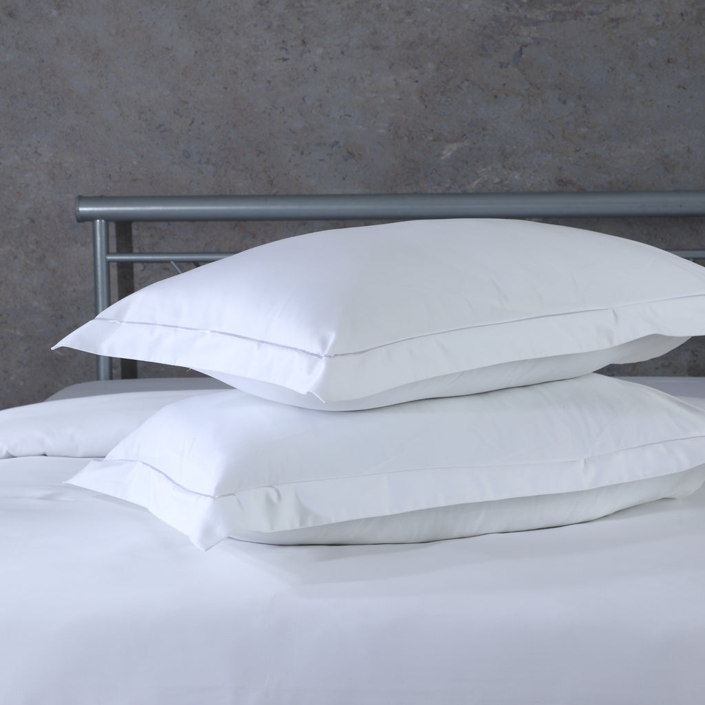 White oxford pillowcase set on a styled bed – 600 TC organic cotton with single embroidered border on face and flange, Whites of London