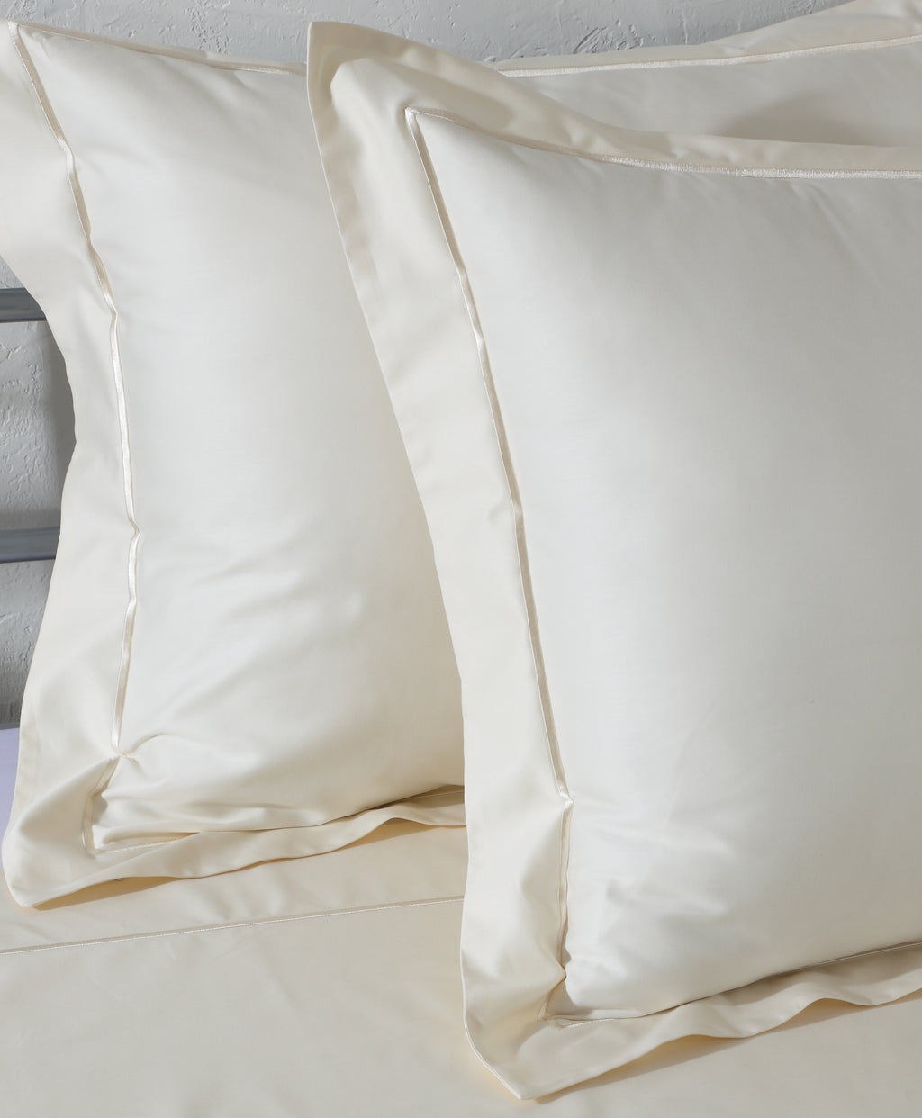 Close-up of marrow embroidery line on an ivory 600TC organic cotton flat sheet – fine single-line stitching along the top hem, silky high thread count weave
