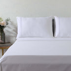 1000 TC white organic cotton embroidered sheet set on a luxury styled bed – silky flat sheet with three embroidery line and matching pillowcases, Whites of London