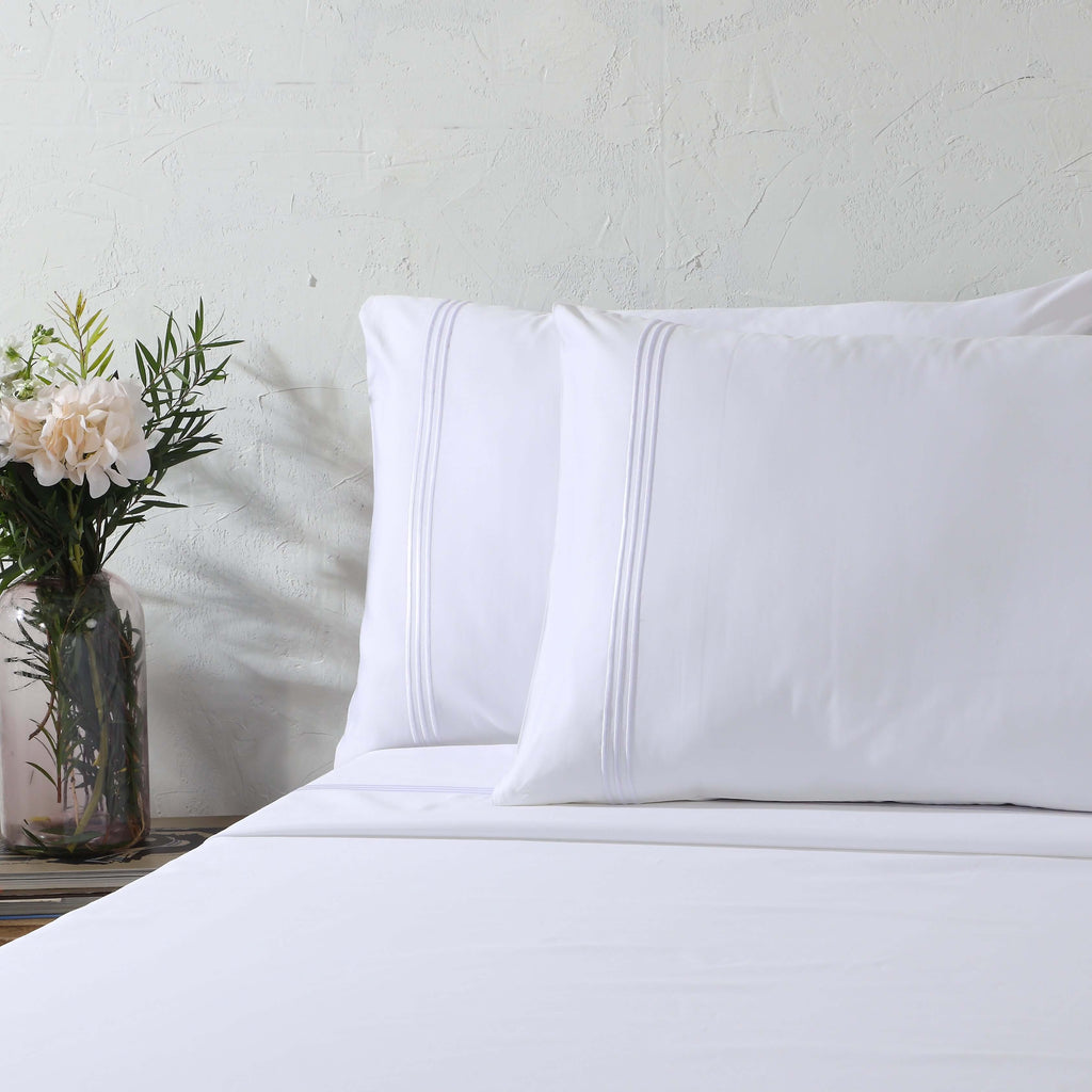 White 1000 thread count organic cotton sheet set on a made bed – pristine flat sheet and embroidered housewife pillowcases, smooth and silky, Whites of London India