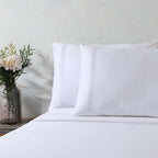 White 1000 thread count organic cotton sheet set on a made bed – pristine flat sheet and embroidered housewife pillowcases, smooth and silky, Whites of London India