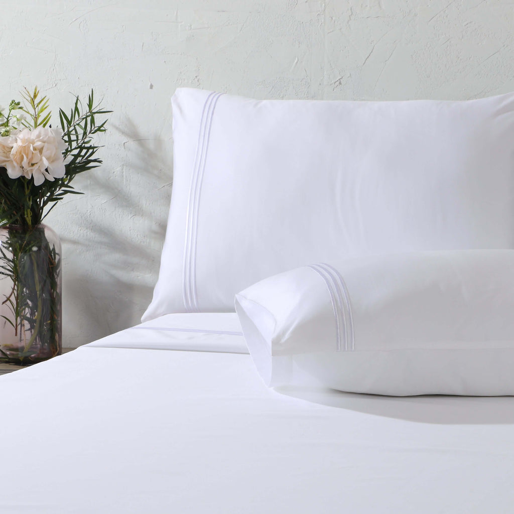 Close-up of marrow embroidery detail on a white 1000 TC organic cotton flat sheet – fine triple embroidered line along the top hem