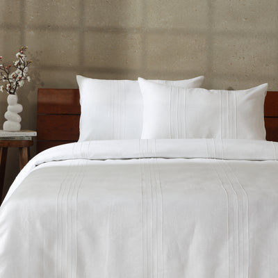 Whisper White Heirloom linen duvet cover set on a luxury styled bed – hand-tailored pintucks and Victorian hemstitching, 100% European flax linen, Whites of London India